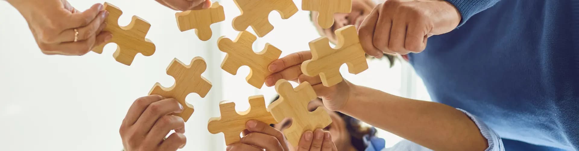 people holding large puzzle pieces