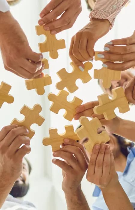 people holding large puzzle pieces